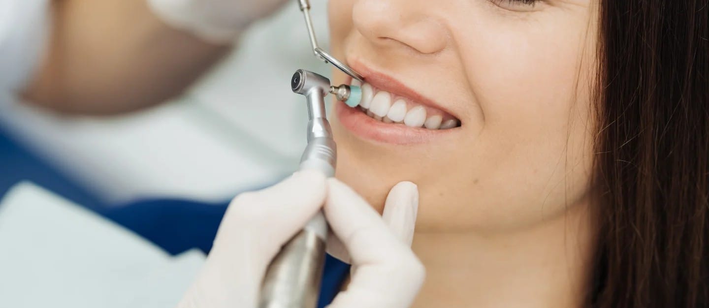 Smiling patient receiving a professional dental cleaning
